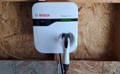 A home charger perched on a garage wall
