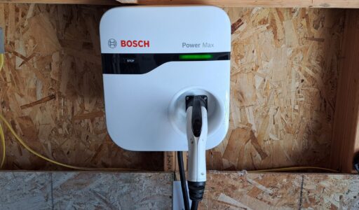 A home charger perched on a garage wall