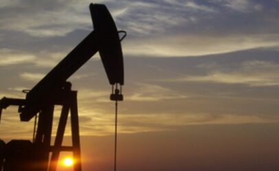 The sun sets on an oil well.