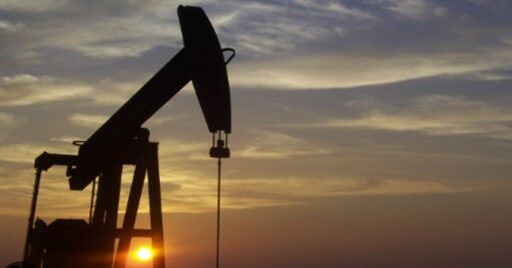 The sun sets on an oil well.